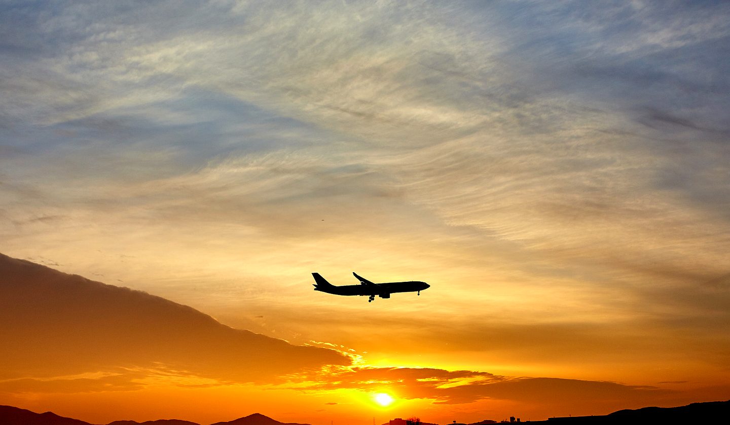 A plane landing at sunset