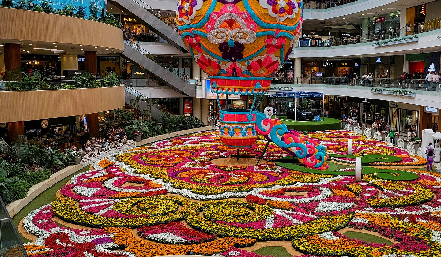 A mall atrium with a flower-carpet display